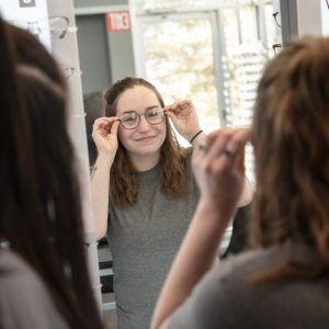 girl trying a new pair of eyeglasses 300x300